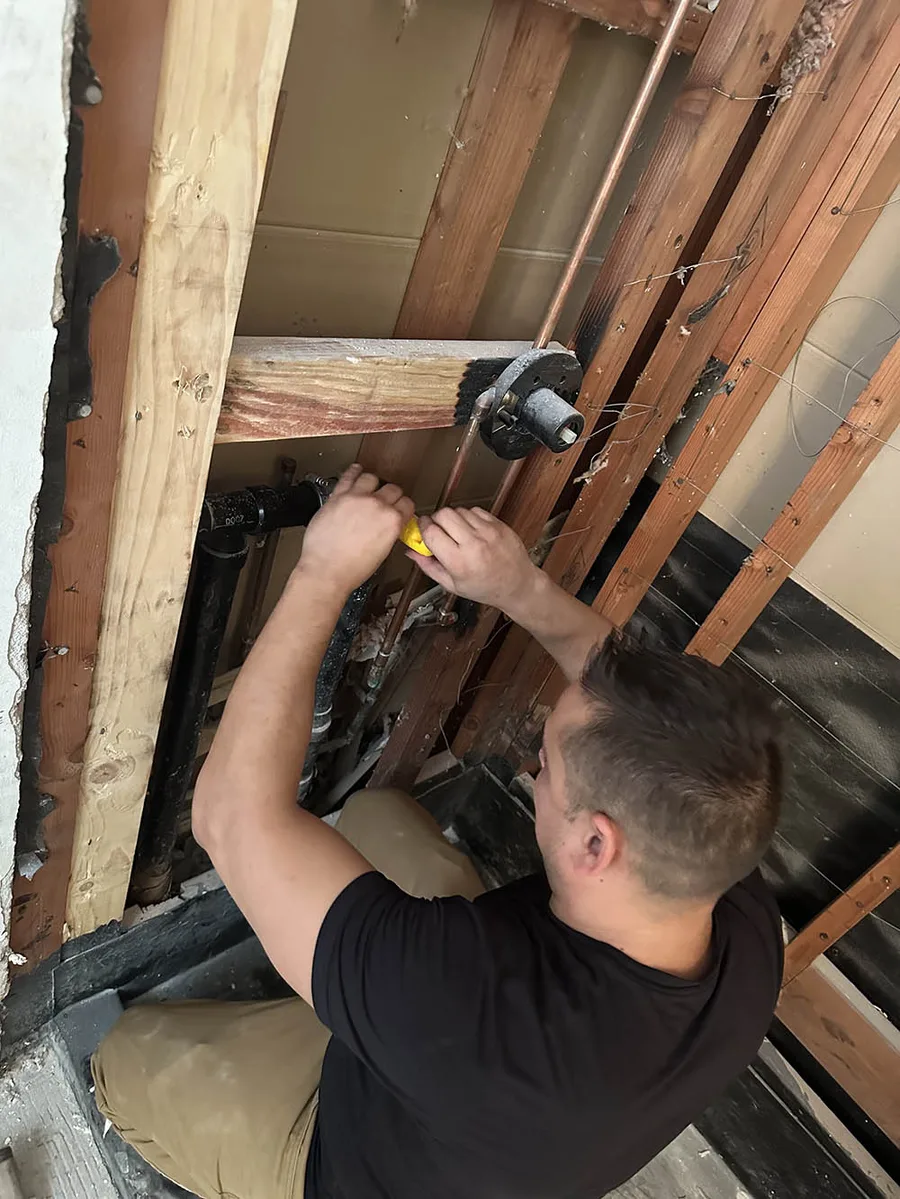 Anthony Fankhauser, owner of Rooter ER Plumbing, repiping a wall in an Orange County home